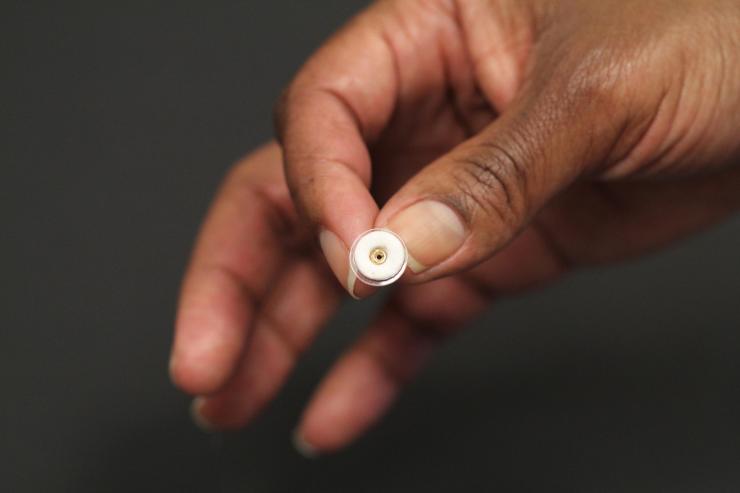 <p>This photograph shows an earring patch (white) that can deliver contraceptive hormone while being worn on an earring back. The size of the patch is about one square centimeter. (Credit: Mark Prausnitz, Georgia Tech)</p>