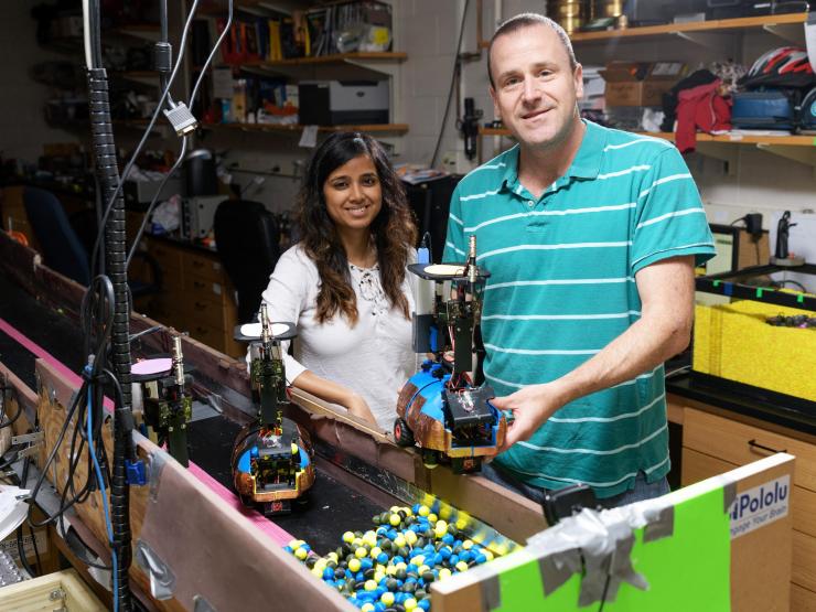 <p>Georgia Tech Graduate Research Assistant Bahnisikha Dutta and Professor Daniel Goldman are shown with autonomous robots built to understand the challenges of moving in confined spaces such as tunnels. (Credit: Rob Felt, Georgia Tech)</p>