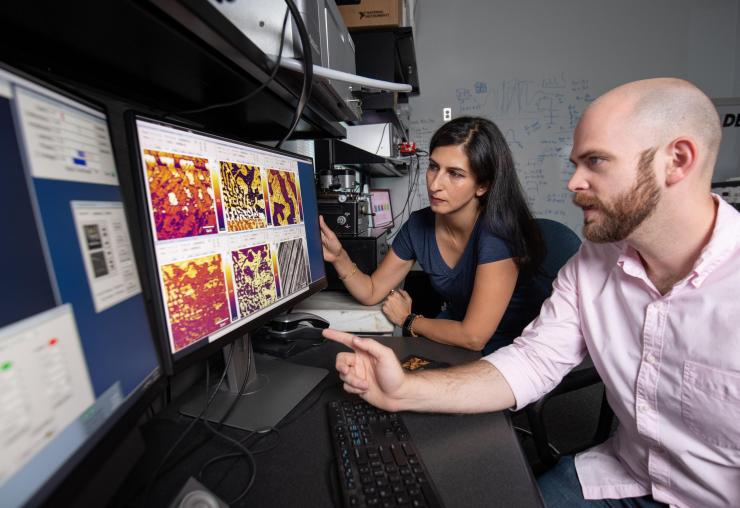 <p>Professor Nazanin Bassiri-Gharb and Ph.D. Candidate Lee Griffin discuss the electromechanical amplitude response of a single crystal as acquired by a modified atomic force microscope (i.e., a piezoresponse force microscope). (Photo: Rob Felt, Georgia Tech)</p>