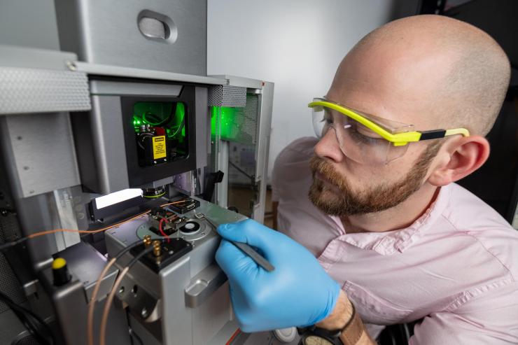 <p>Georgia Tech Ph.D. Candidate Lee Griffin places the single crystal sample onto the measurement stage of the modified atomic force microscope (i.e. piezoresponse force microscope). (Photo: Rob Felt, Georgia Tech)</p>