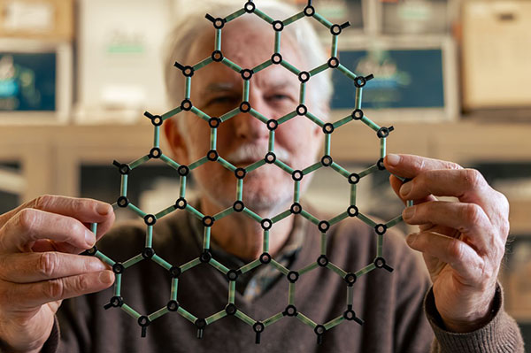 Walter de Heer, a professor of physics at Georgia Institute of Technology, holds a molecular model of graphene in his lab.
