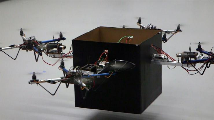 <p>Four small drones work together to lift a package. An adaptive control algorithm could allow a wide range of packages to be delivered using a combination of several standard-sized vehicles. (Georgia Tech photo)</p>