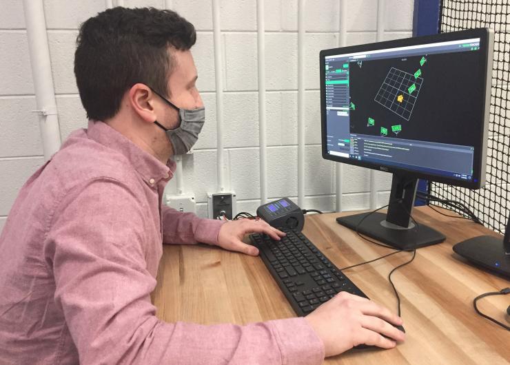 <p>Graduate student Kevin Webb monitors the control algorithm that allows four drones to team up to pick up and deliver a package. (Credit: John Toon, Georgia Tech)</p>