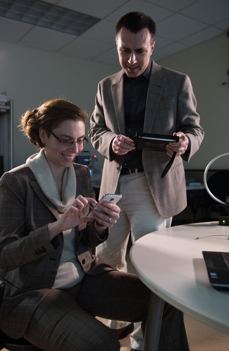 <p>Georgia Tech researchers Alenka Zajic and Milos Prvulovic use a simple AM/FM radio to pick up side-channel signals from a cell phone. Such unintentional signals could be used to learn what computations are being done by the device.  (Credit: Rob Felt)</p>