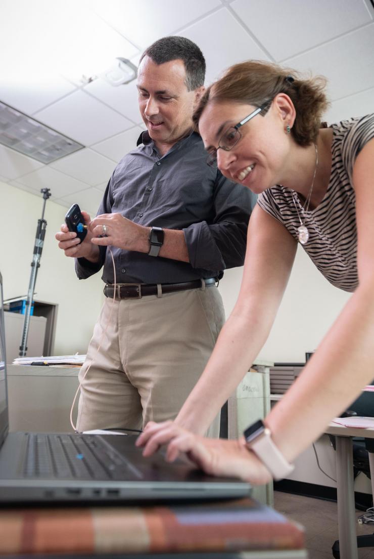 <p>Milos Prvulovic and Alenka Zajic use a tiny probe near the phone to capture the signal that is analyzed on the laptop to accomplish the side channel attack.  (Credit: Allison Carter, Georgia Tech)</p>