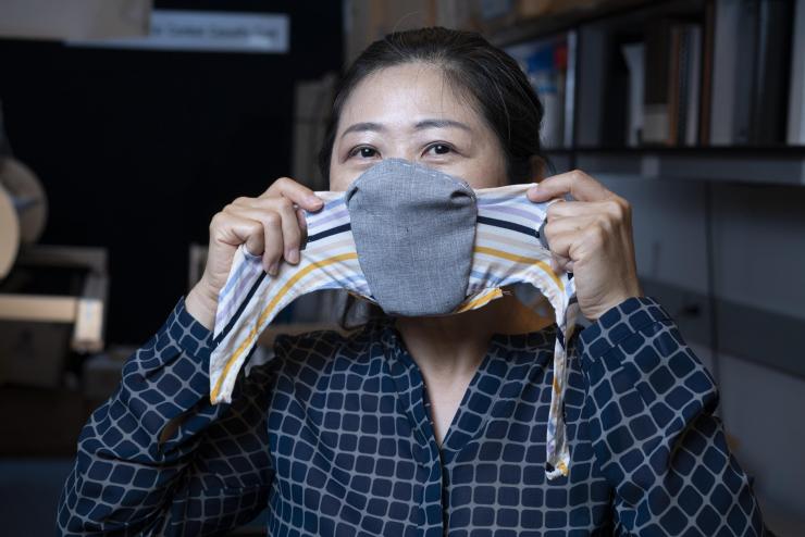 <p>Principal research scientist Sungmee Park shows how the redesigned face mask is worn. (Credit: Christopher Moore, Georgia Tech).</p>