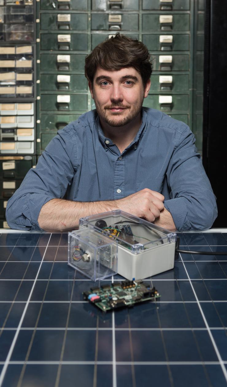 <p>Researcher Lee W. Lerner displays an FPGA board along with a custom sensor box built by the GTRI team for research purposes. (Georgia Tech Photo: Rob Felt)</p>