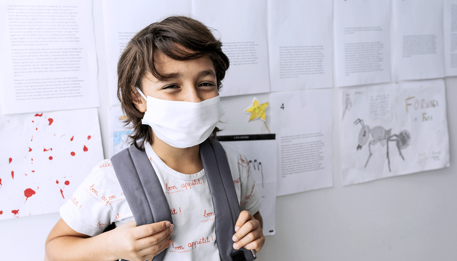 A young student wearing a mask