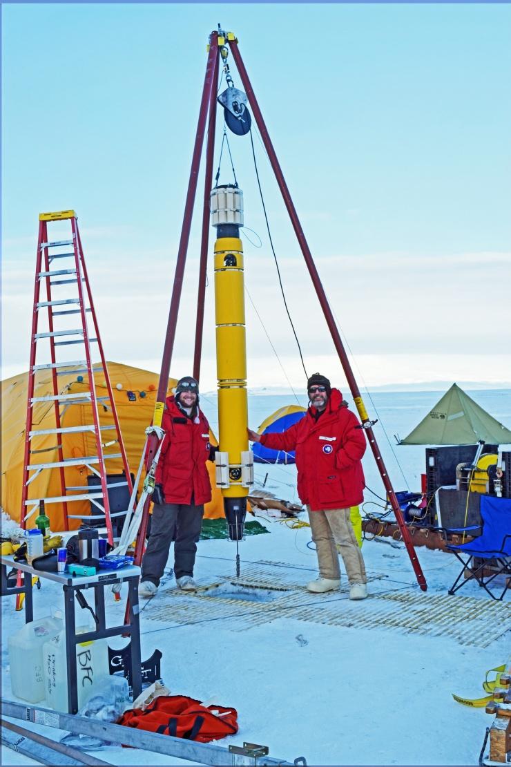 <p>A robotic submarine outfitted to probe for signs of life is lowered under the ice in Antarctica. In the future, a highly updated version could be placed on a rocket for deployment in under-ice oceans on planetary neighbors in our solar system. Credit: Georgia Tech</p>