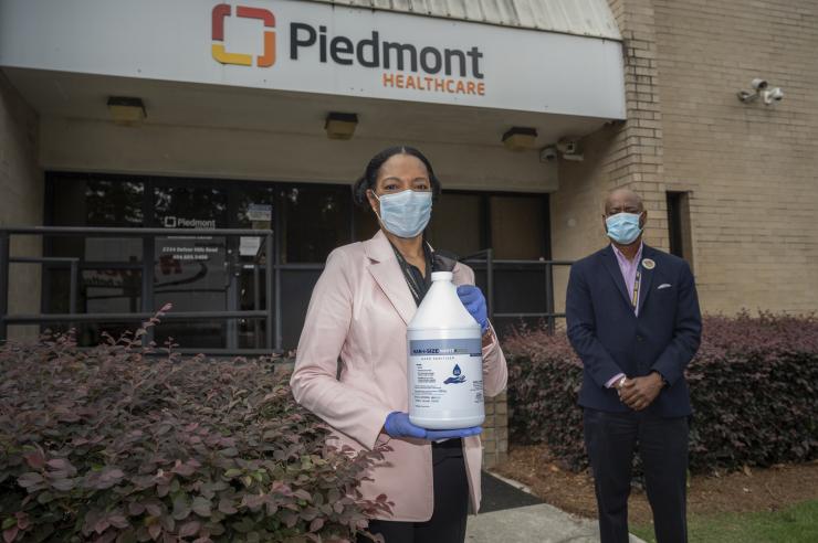 <p>Dr. Jayne Morgan welcomes the first delivery of the newly designed, ethanol-based hand sanitizer to Piedmont Healthcare of Atlanta. Behind her, George White of Georgia Tech, a team member in the hand sanitizer initiative. Georgia Tech / Christopher Moore</p>
