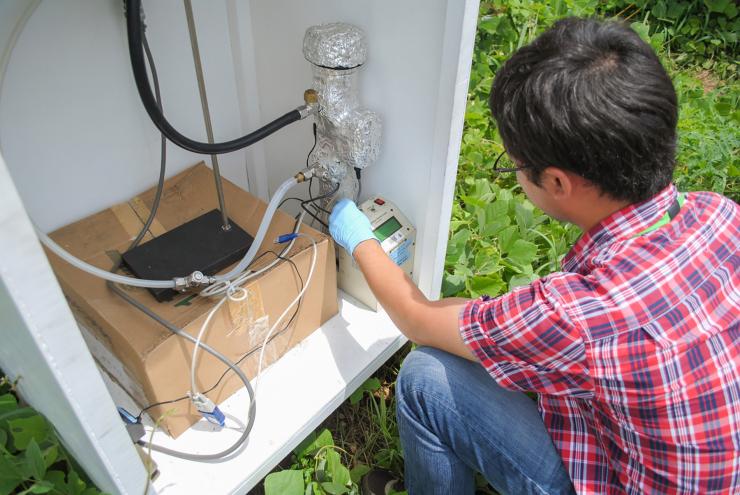 <p>School of Earth and Atmospheric Sciences graduate student Hongyu Guo measures how atmospheric particles are interacting with sunlight during a field study in Alabama’s Talladega National Forest. (Credit: Jason Maderer, Georgia Tech)</p>