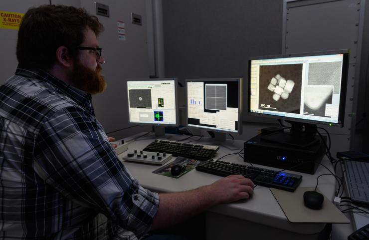 <p>Matthew Boebinger, a graduate student at Georgia Tech, observed video of sodium reacting with an iron sulfide particle. (Credit: Rob Felt)</p>