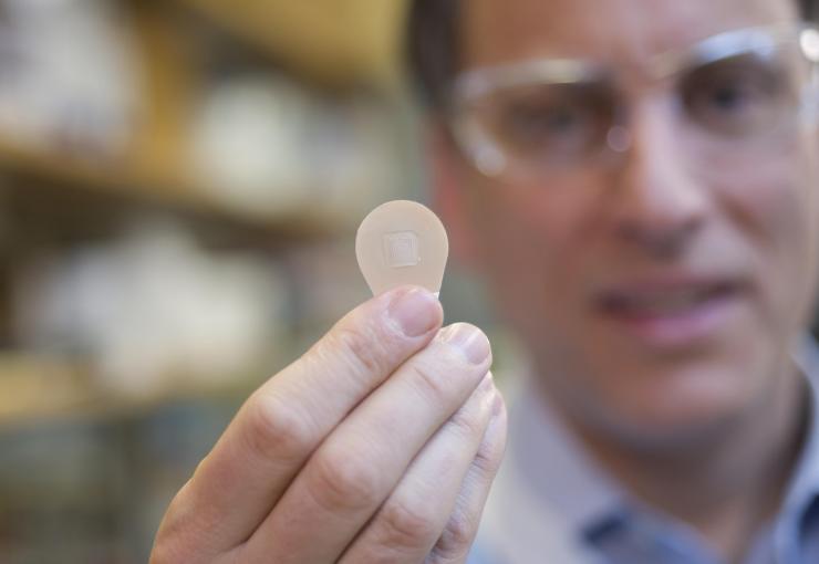 <p>Mark Prausnitz, Ph.D., Georgia Tech Regents professor in the School of Chemical and Biomolecular Engineering, holds a microneedle vaccine patch containing needles that dissolve into the skin. (Credit: Christopher Moore, Georgia Tech)</p>