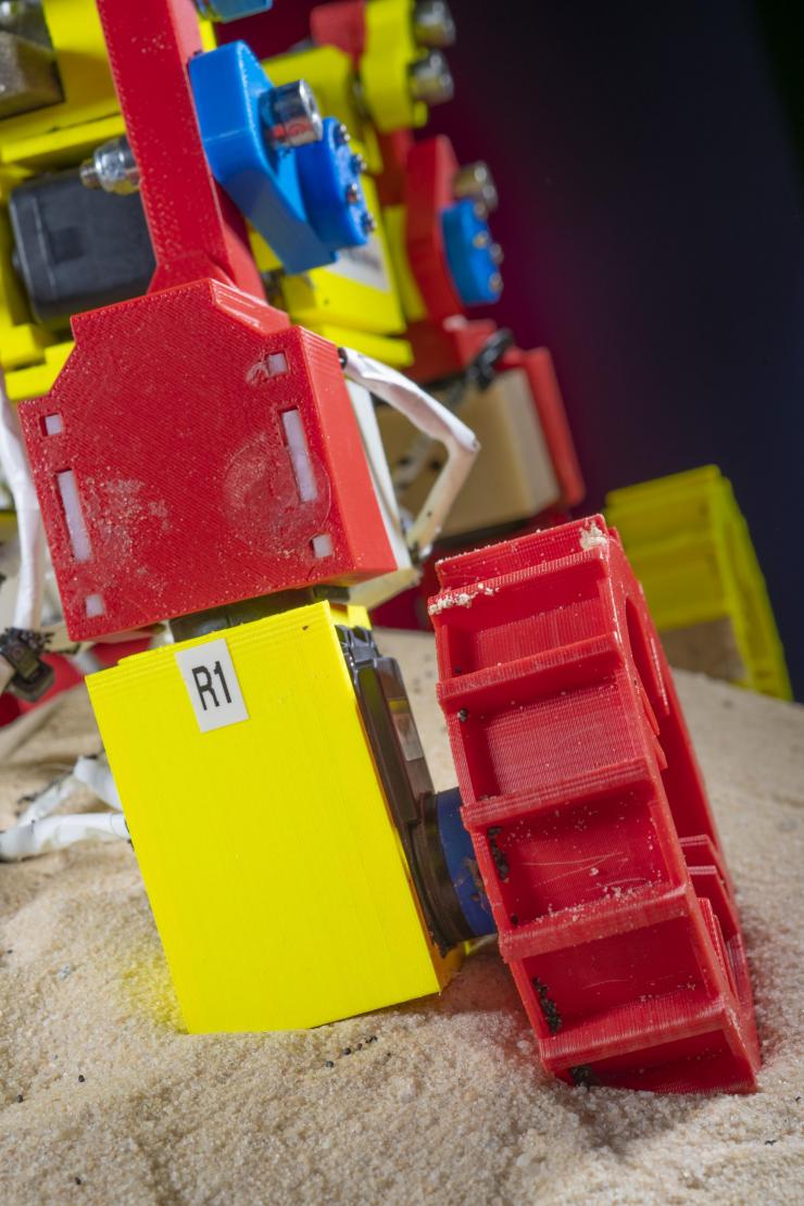<p>This close-up image shows one of the appendages of the Mini Rover. The leg can be raised and lowered and the wheel moved from side to side to move through loose granular surfaces. (Credit: Christopher Moore, Georgia Tech)</p>