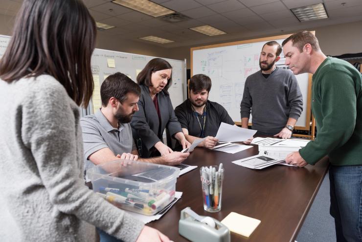 <p>GTRI researchers identify the design requirements in the mission planning task. Shown are Georgia Tech Graduate Student Rachel Chen, Research Engineer Robert Kempf, Senior Research Scientist Marcia Crosland, Research Scientist Chandler Price, Research Scientist Andrew Baranak and Senior Research Scientist C.J. Hutto. (Credit: Rob Felt, Georgia Tech)</p>