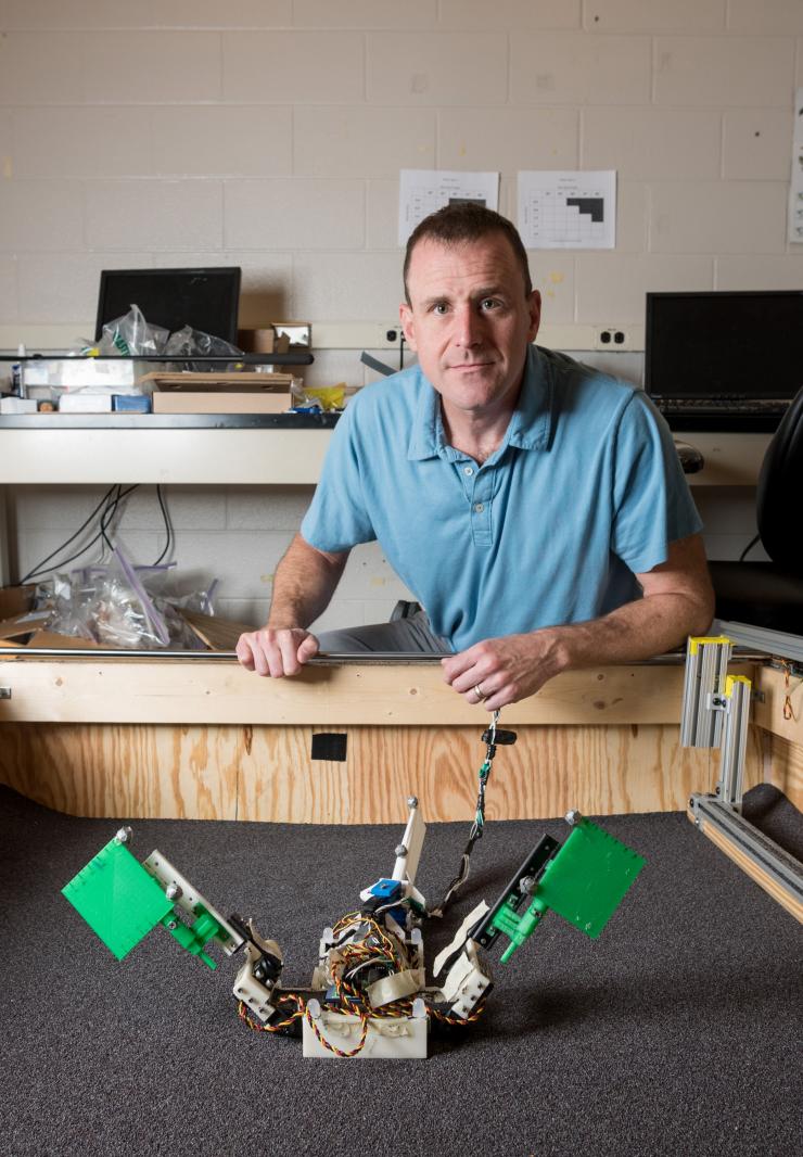 <p>Dan Goldman, associate professor in the Georgia Tech School of Physics, is shown with the “MuddyBot” robot in a trackway used to study how the robot – which was modeled on the mudskipper fish – moved across granular surfaces. (Credit: Rob Felt, Georgia Tech)</p>