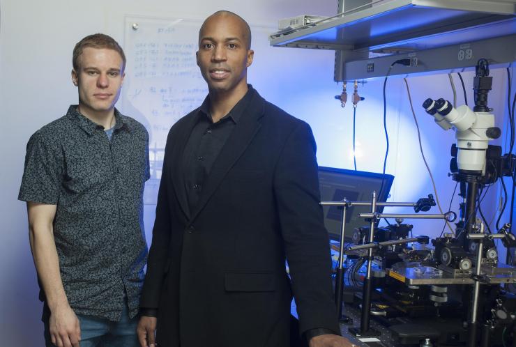 <p>NSF Graduate Research Fellow Erik Anderson (left) and Associate Professor Baratunde Cola are shown with optical equipment used to test a new rectenna design. (Credit: Christopher Moore, Georgia Tech)</p>