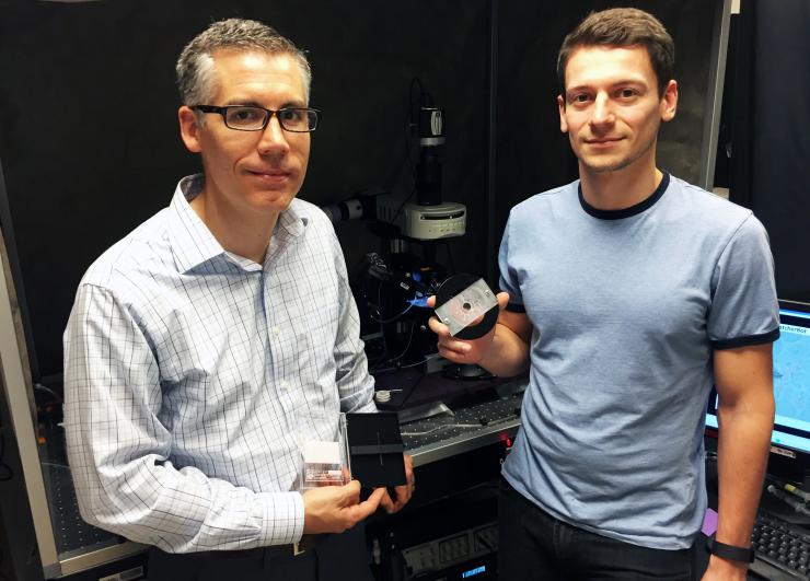 <p>Georgia Tech associate professor Craig Forest (left) and graduate research assistant Ilya Kolb with the robotic patch-clamping equipment that can automate the process of recording without stopping to replace pipettes. (Credit: John Toon, Georgia Tech)</p>