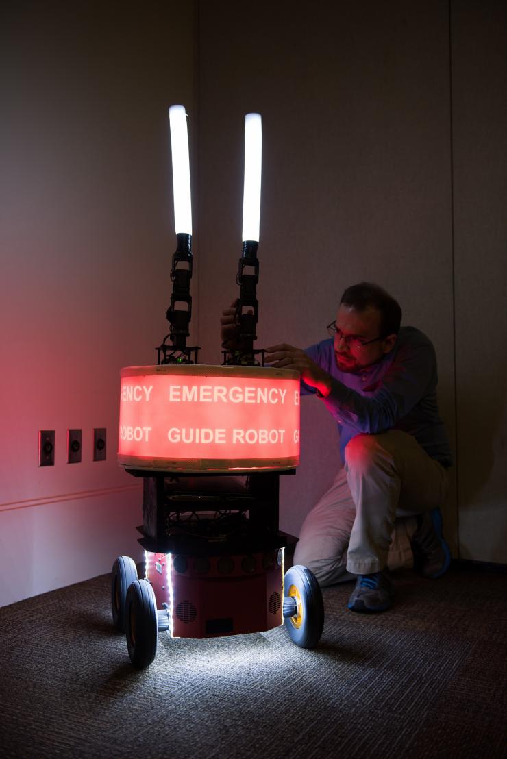 <p>Georgia Tech Research Institute (GTRI) Research Engineer Paul Robinette adjusts the arms of the “Rescue Robot,” which was built to study issues of trust between humans and robots. (Credit: Rob Felt, Georgia Tech)</p>