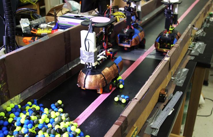 <p>Photograph shows three robots working in close proximity in a confined space. Adding a fourth robot created a traffic jam that brought digging to a halt. (Georgia Tech photo)</p>