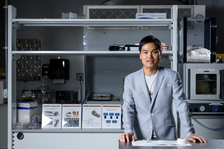 <p>Woon-Hong Yeo, an assistant professor in the Woodruff School of Mechanical Engineering and Institute for Electronics and Nanotechnology at the Georgia Institute of Technology, is shown with the sodium sensor in his laboratory. (Credit: Rob Felt, Georgia Tech).</p>