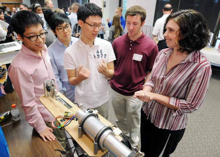 <p>Left to right: Seongil (Sean) Ko and  Albert Lee of Johns Creek H.S., and Saheon (Eric) Kim of Walton High School – all members of the motor propeller testing team – discuss their testing stand with mentor David Moroniti and STEP director Kelly Griendling at the program’s award event. (Credit: Gary Meek)</p>