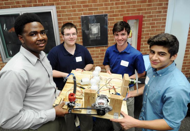<p>Left to right, Brandon Ringfield and Austin Pettit of Lithia Spring High School, Gavin Hudnall of Roswell High School and Alan Amedi of the Paideia School display their hybrid electric drive design at the STEP final awards event. (Credit: Gary Meek)</p>