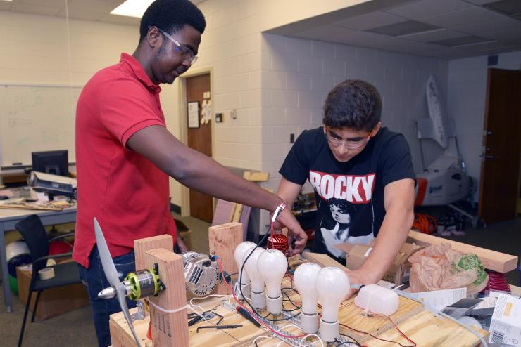 <p>Brandon Ringfield, left, of Lithia Springs High School and Alan Amedi of the Paideia School construct a hybrid-electric unmanned aerial vehicle. (Credit: Rick Robinson)</p>