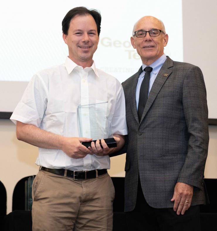 Chris Rozell accepts his award from Georgia Tech Provost Rafael Bras.