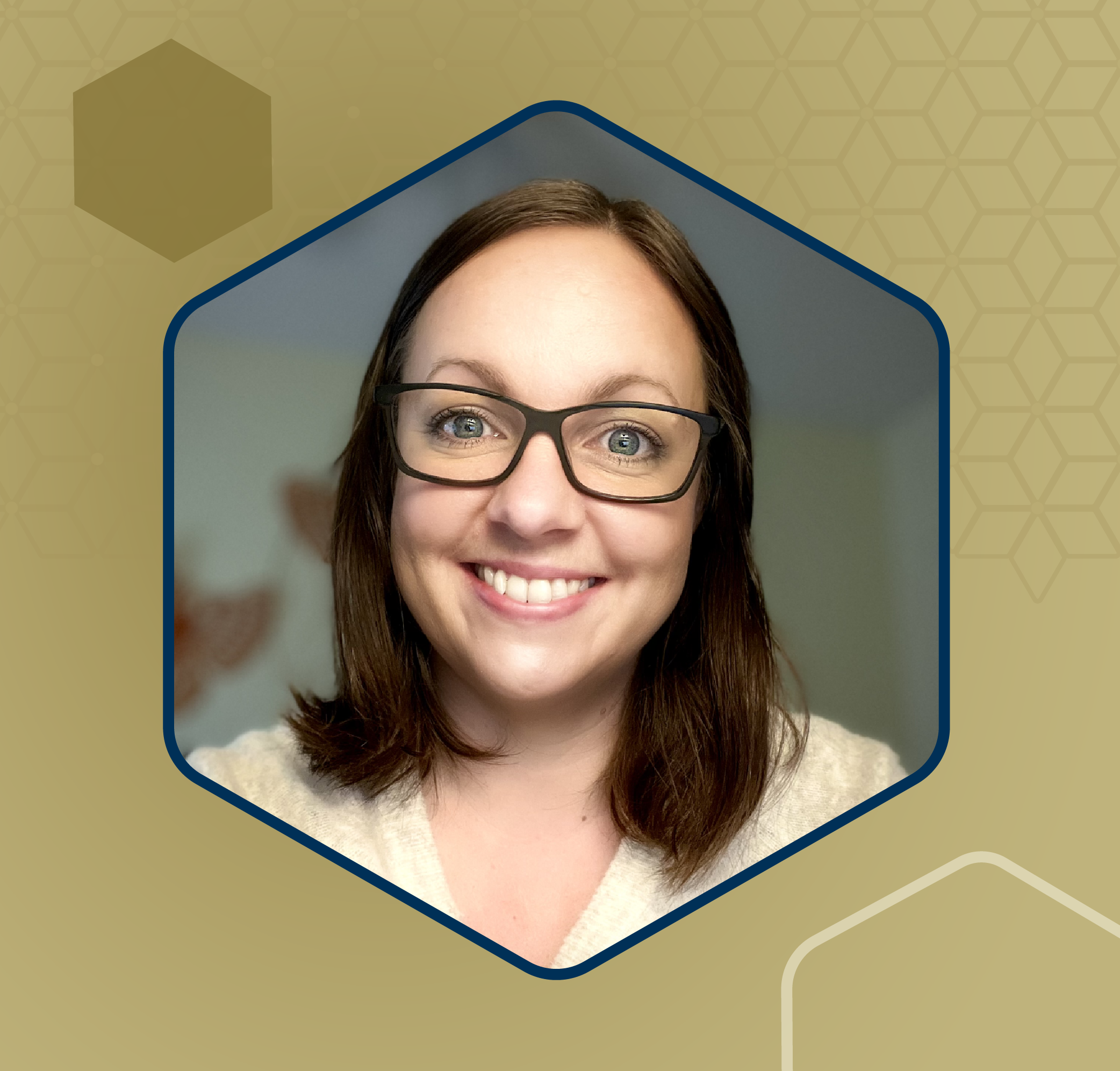 Professional headshot of an individual wearing a light-colored top against an indoor background.