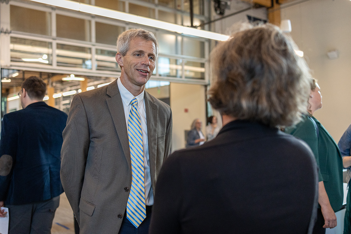 Tim Lieuwen speaking to a woman while standing in a lobby