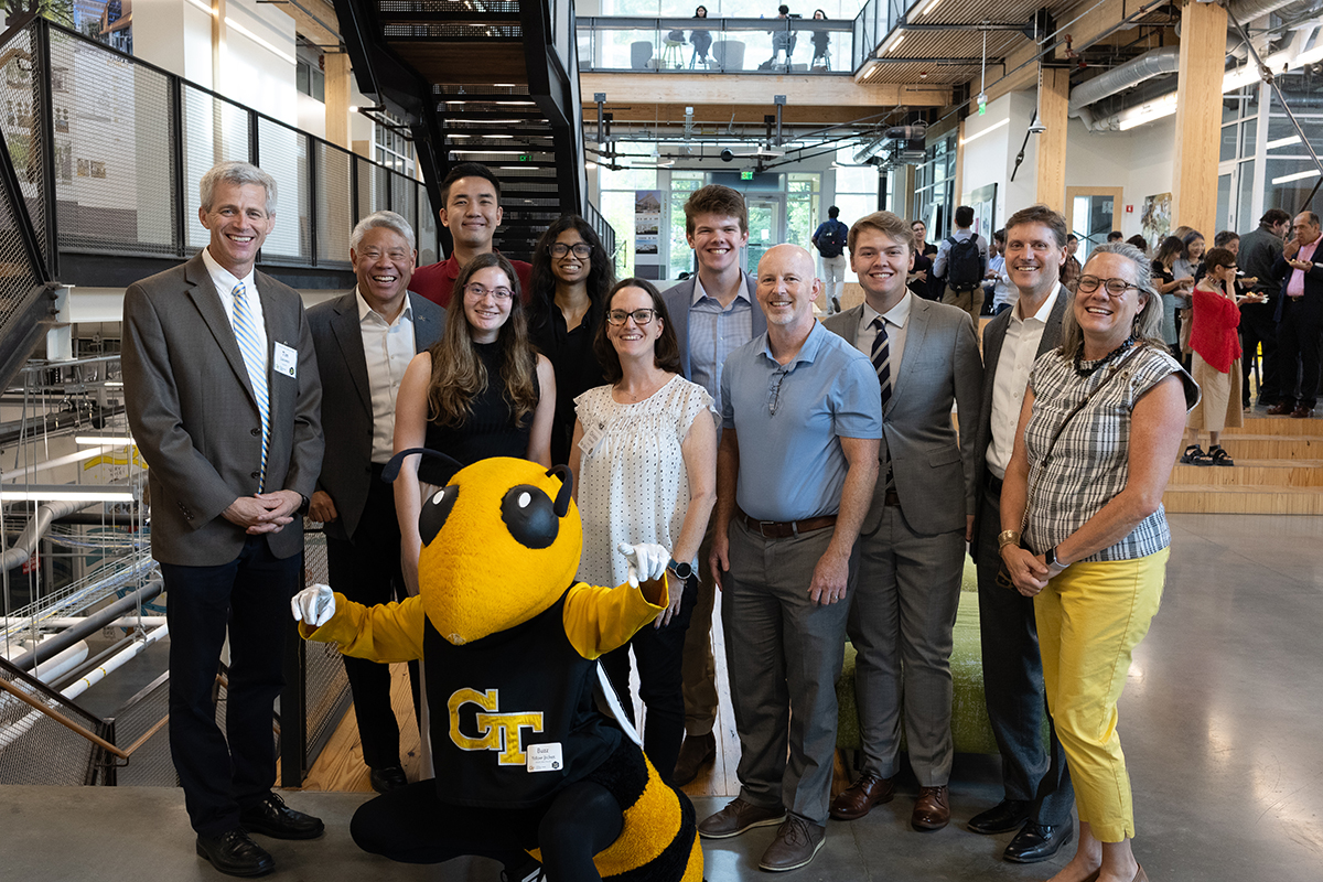 The SEI team standing in the lobby with Buzz, the GT mascot, in the front