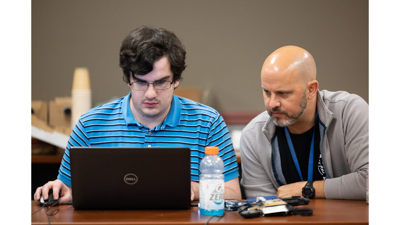 Chris Roberts (right), a GTRI principal research engineer who leads CIPHER's Embedded Cyber Techniques branch, said hackathons and CTFs teach participants teamwork and problem-solving skills that extend into the workplace (Photo Credit: Ethan Trewhitt). 