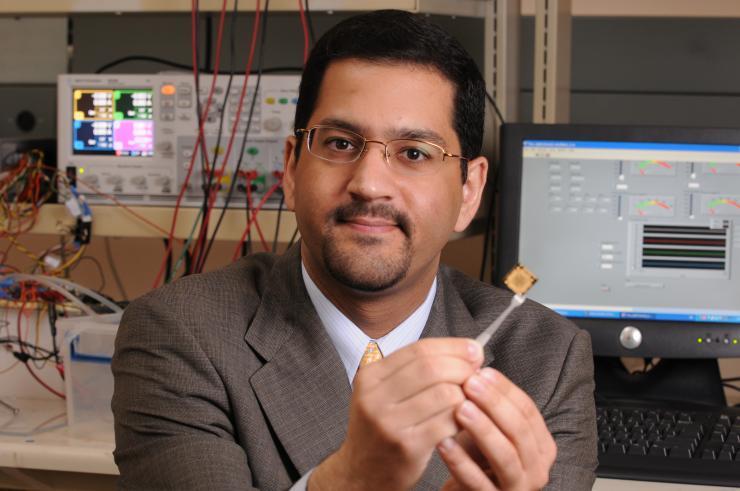 Muhannad Bakir, a professor in the School of Electrical and Computer Engineering, holding a monolithic microelectronics chip. He brings a breadth of knowledge to the shift from monolithic microelectronics to heterogeneous integration. (Photo credit: Robert Felt, Georgia Tech)