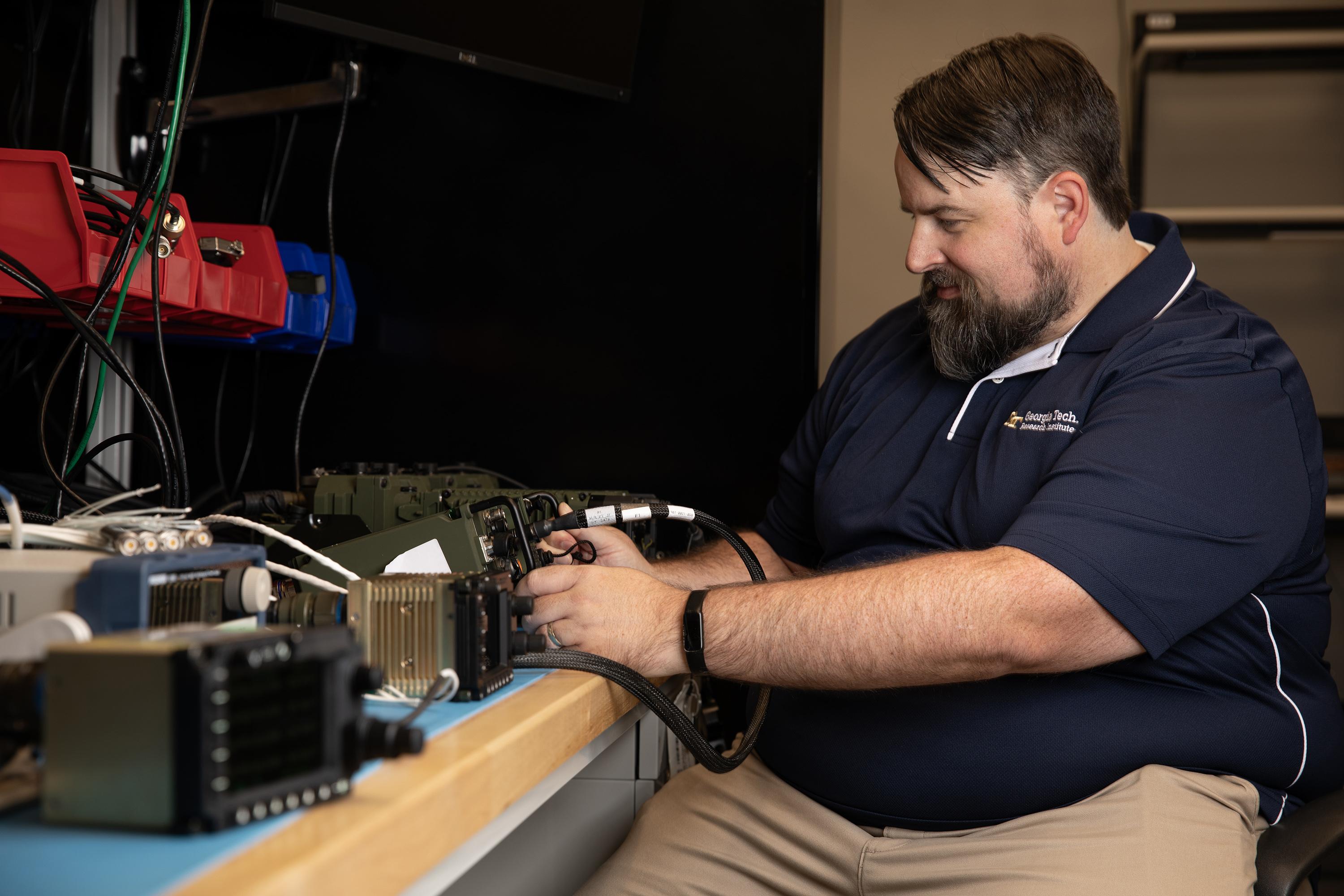 GTRI Senior Research Engineer Scott Tompkins is shown reconfiguring an Air Ground Networking Radio (AGNR) for testing