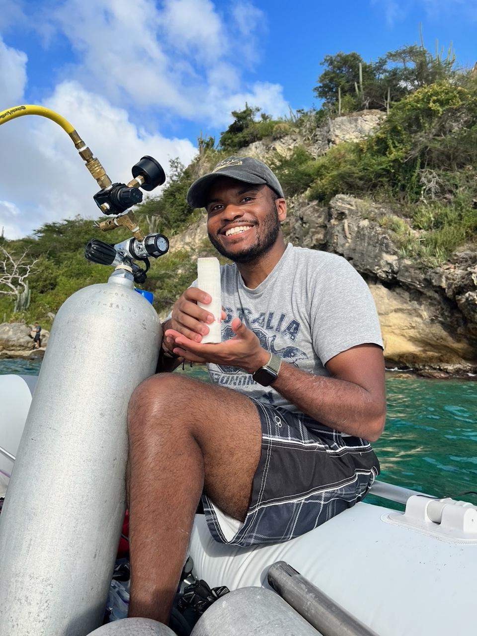 Man holds coral on boat