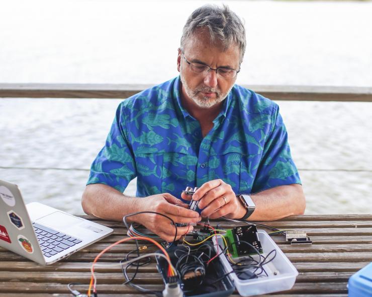 <p>Russell Clark assembling a sea level sensor on Georgia coastline</p>