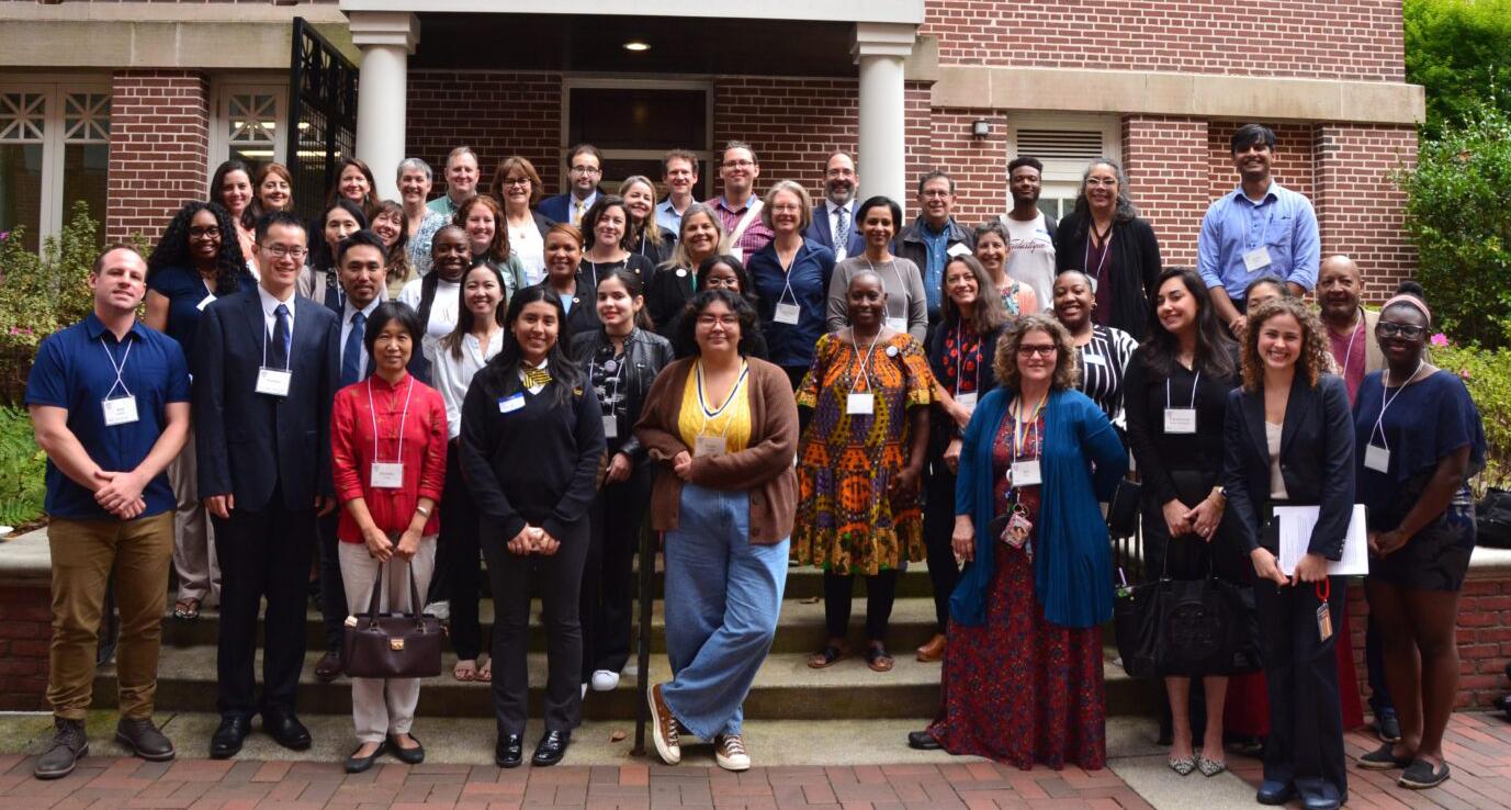 A group of attendees to the RCE Americas meeting in Atlanta pose for a group photo outside a red brick Georgia Tech building.