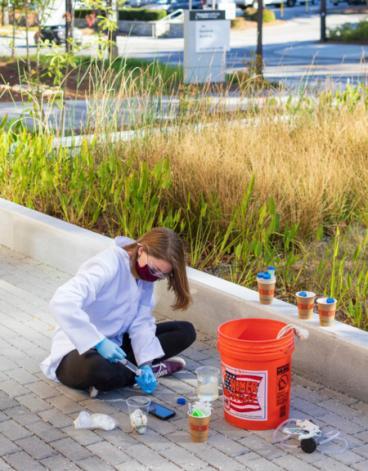 <p>A student takes water samples from a reed bed at the Kendeda Builiding for Innovative Sustainable Design.</p>
