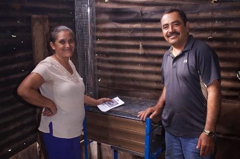 <p>Residents of Nuevo Amanecer in Nicaragua stand with their new clean cookstove, installed in 2019. Credit: Engineers Without Borders</p>