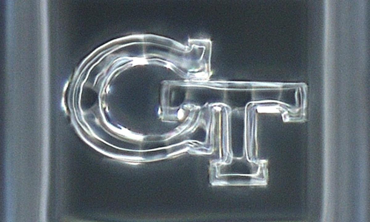 a 3D printed silica glass "GT" logo