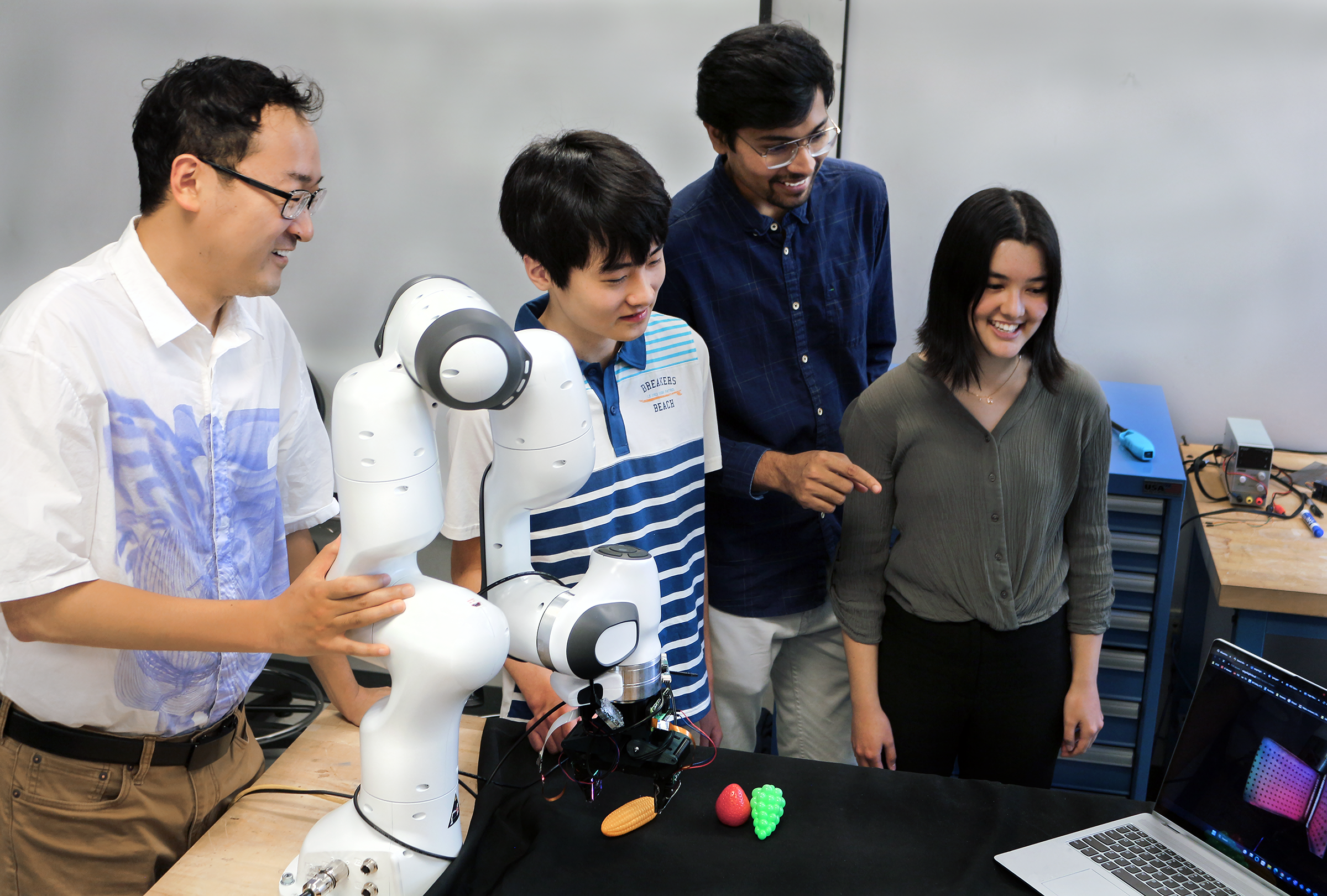 l-r: Professor Ye Zhao, high school intern Matthew Zhu, graduate student Chaitanya Mehta, and high school intern Christian Hable with the lab's robotic arm with tactile sensors