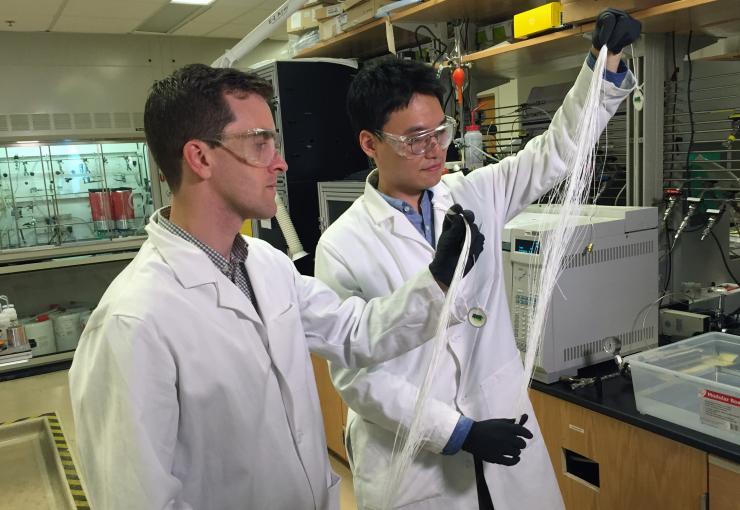 <p>Georgia Tech Assistant Professor Ryan Lively (left) and Postdoctoral Fellow Dong-Yeun Koh hold bundles of hollow polymer fibers that serve as precursors for the carbon membrane fiber used to separate alkyl aromatic chemicals. (Credit: John Toon, Georgia Tech)</p>