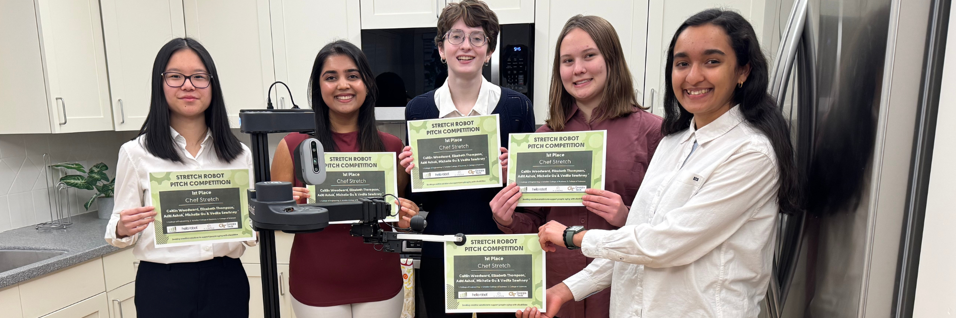 Michelle Gu, Aditi Ashok, Caitlin Woodward, Elizabeth Thompson, and Vedita Sawhney pose with Stretch and their award certificates. They won $1000 and the opportunity to develop their concept in the Aware Home. 