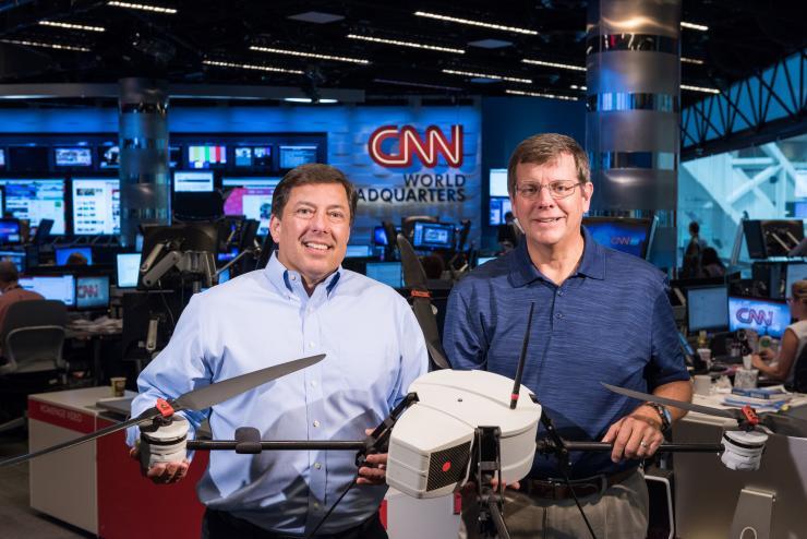 <p>The Georgia Tech Research Institute (GTRI) and CNN have been working together to study the issues affecting the use of unmanned aerial vehicles for newsgathering. Shown in CNN’s World Headquarters are (left) Greg Agvent, senior director of news operations for CNN, and Cliff Eckert, a GTRI senior research associate who’s working on the project. They are shown with an AirRobot AR 180, one of the devices that may be suitable for newsgathering. (Credit: Rob Felt, Georgia Tech)</p>