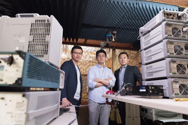 <p>Georgia Tech researchers are shown with electronics equipment and antenna setup used to measure far-field radiated output signal from millimeter wave transmitters. Shown are Graduate Research Assistant Huy Thong Nguyen, Graduate Research Assistant Sensen Li, and Assistant Professor Hua Wang. (Credit: Allison Carter, Georgia Tech)</p>