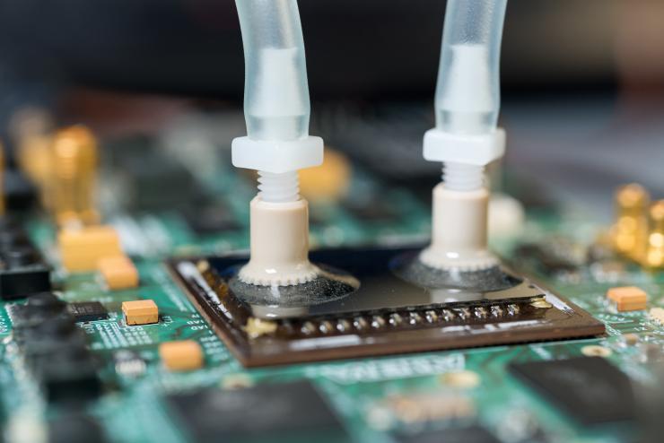 <p>Liquid ports carry cooling water to specially designed passages etched into the backs of FPGA devices to provide more effective cooling. The liquid cooling provides a significant advantage in computing throughput. (Credit: Rob Felt, Georgia Tech)</p>