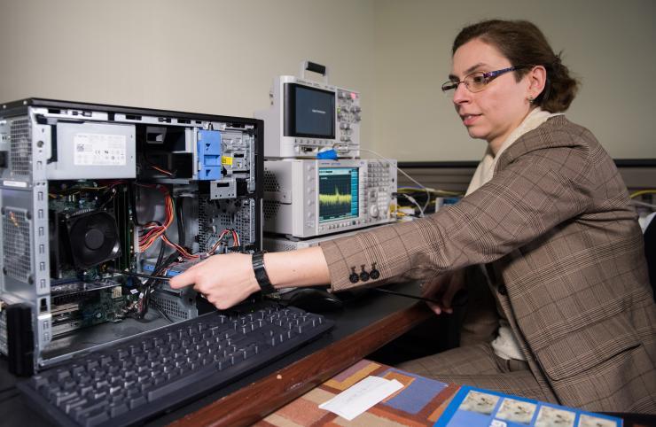 <p>Georgia Tech researcher Alenka Zajic measures electromagnetic emissions from various components of a desktop computer. The researchers have studied emissions from desktop and laptop computers, as well as cellphones. (Credit: Rob Felt)</p>