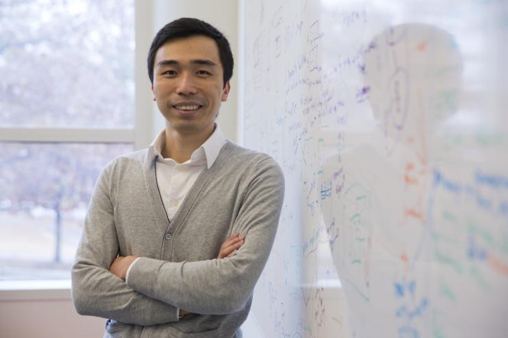 <p>CSE Associate Professor Polo Chau stands in front of a white board with equations written on it.</p>