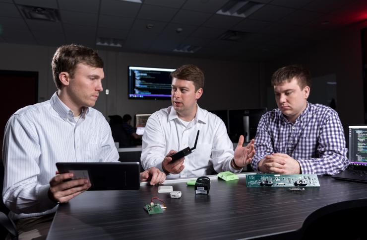 <p>GTRI researchers (l-r) Heyward Adams, Andrew Hardin and Greg Bishop examine Internet of Things devices whose output can be integrated using GTRI’s new FUSE software. (Credit: Rob Felt, Georgia Tech)</p>